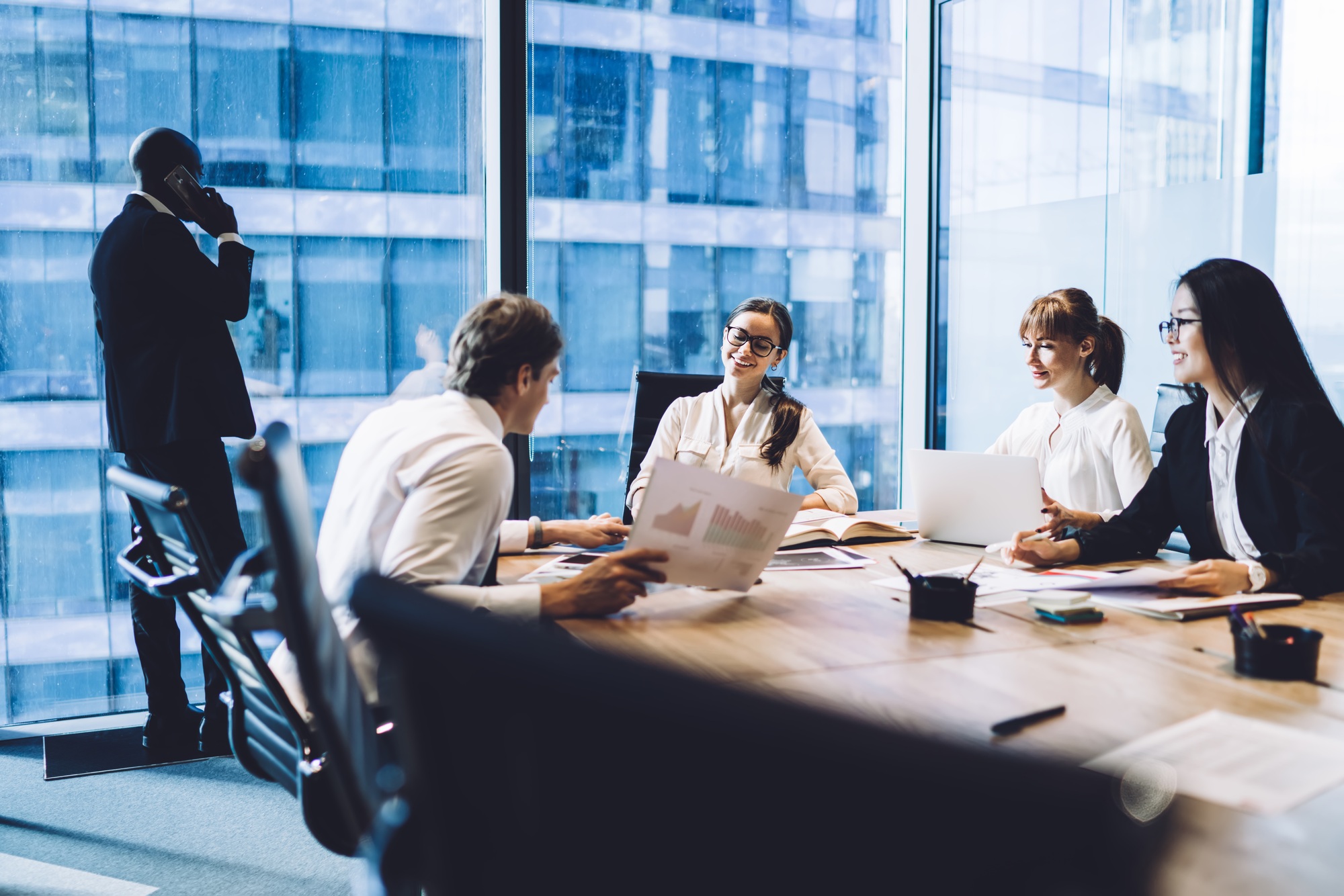 Cheerful colleagues discussing business results in office